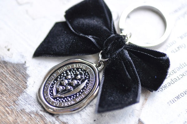 Message Wax Seal Keychain Black Bow | Lily of the Valley - Backtozero B20 - bow, charm, enamel, enamel keychain, Flower, her, keychain, lapel, lily of the valley, metal, ribbon, seashell, soft enamel, starry, velvet, wax seal